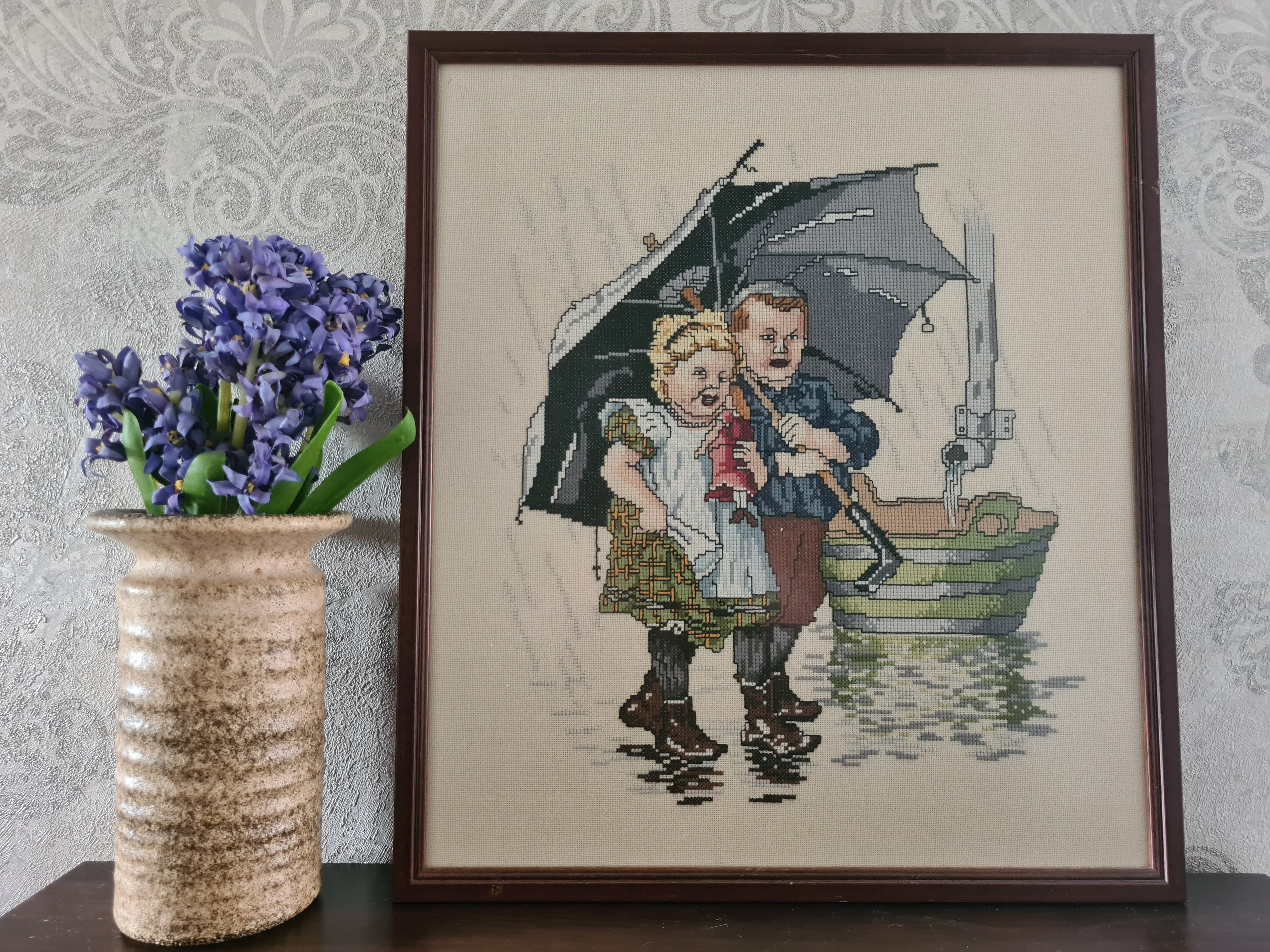 Ingelijst borduurwerk Ot & Sien onder moeders paraplu