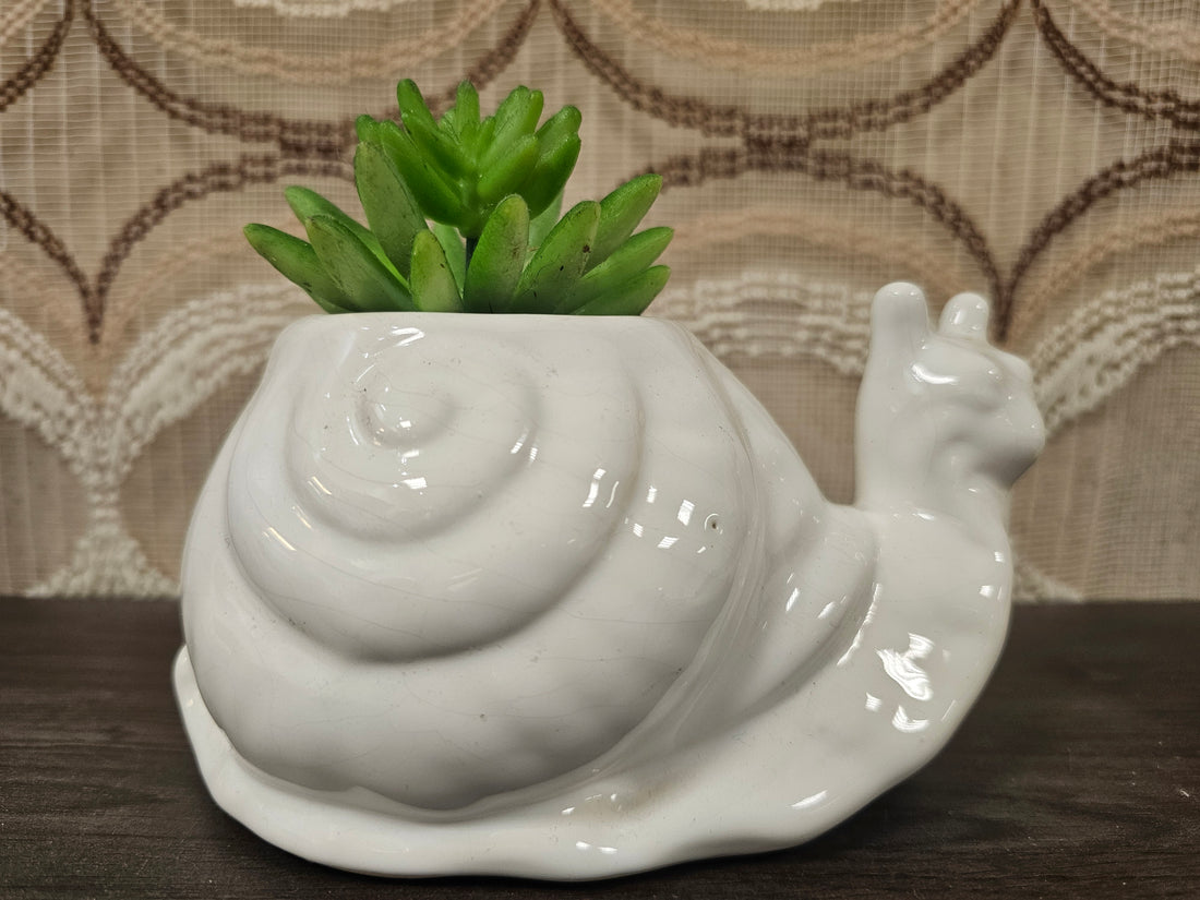 Witte keramieken bloempot in de vorm van een slak