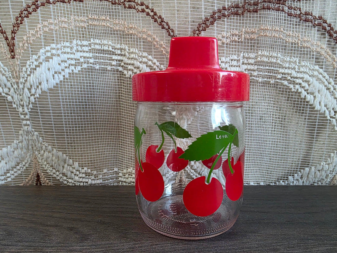 Vintage glazen voorraadpot met kersen en rode dop