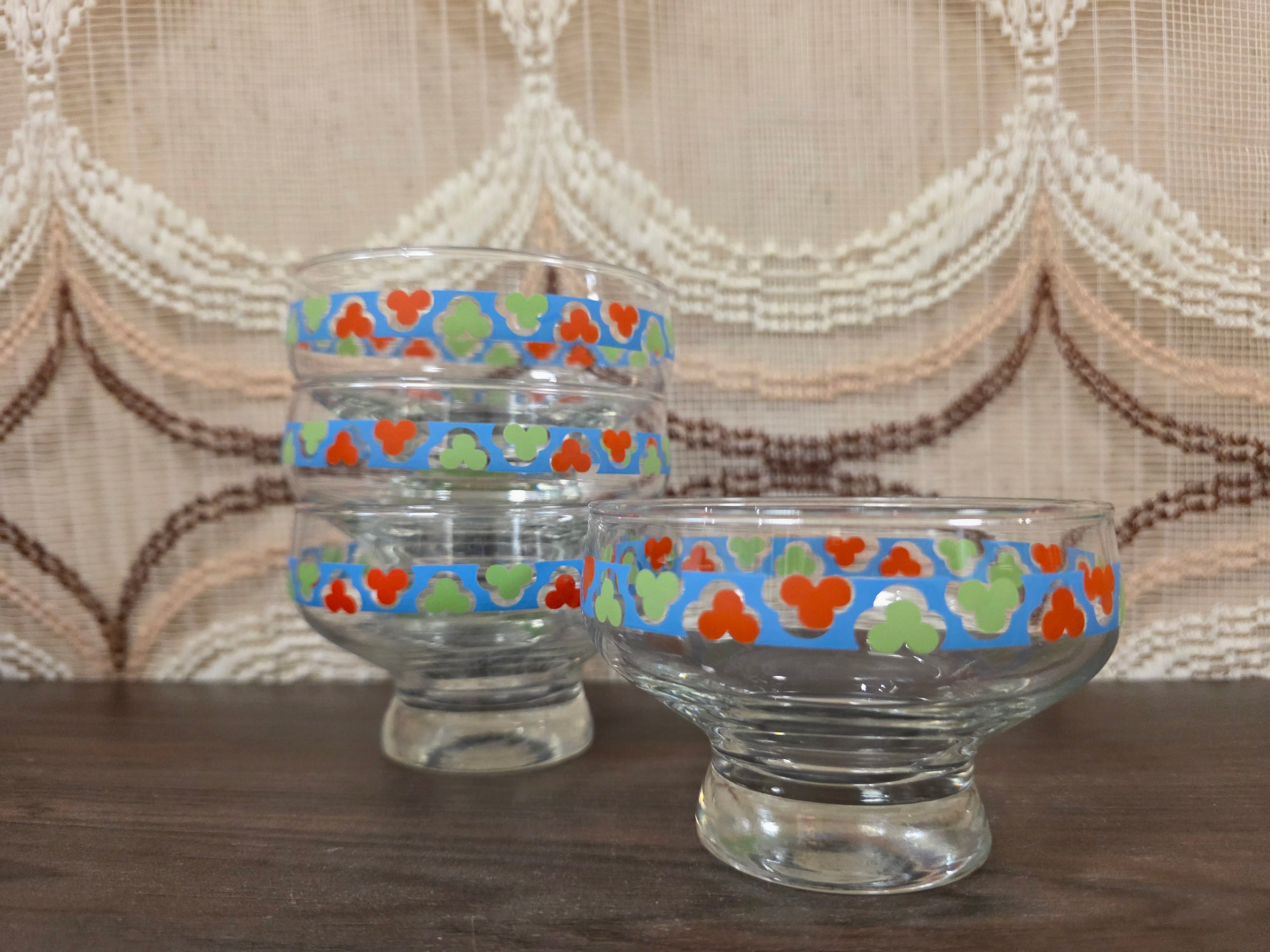vintage glazen dessertschaaltjes op voet met blauw, rood, groen en wit decor.