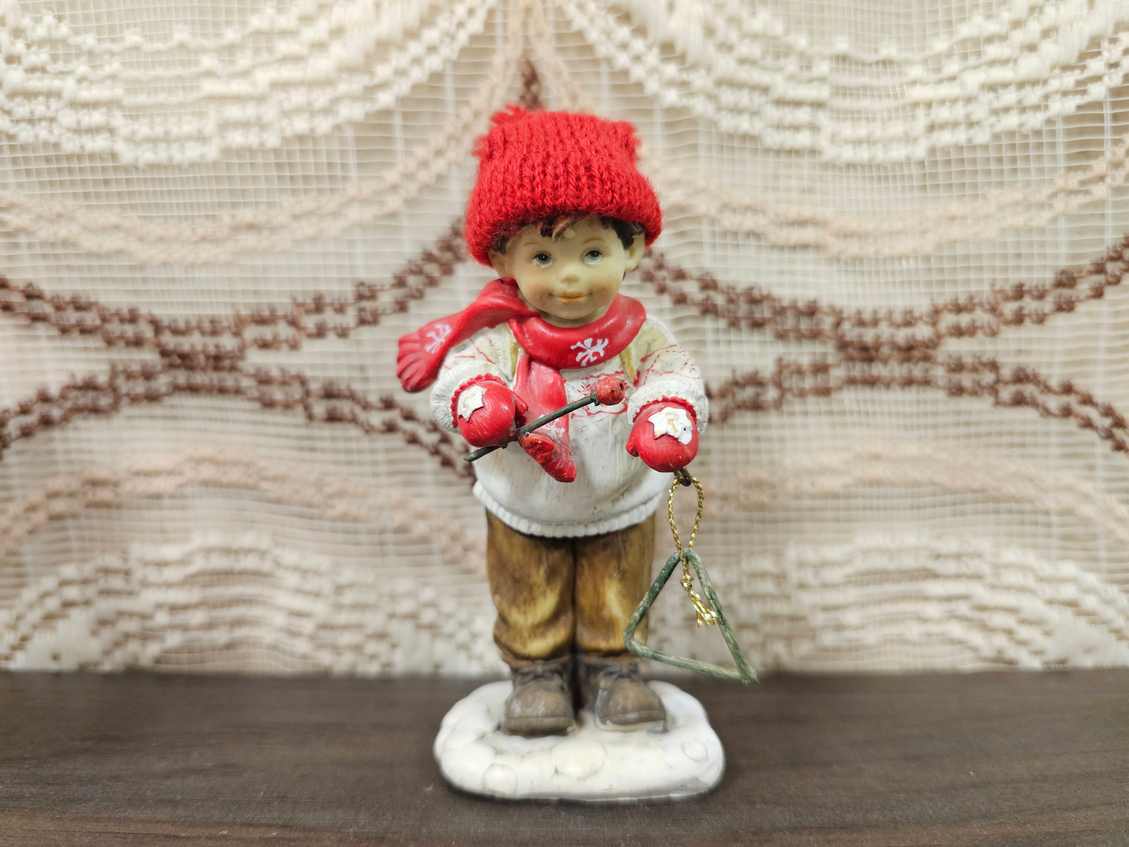 Kerstbeeldje jongen met triangel en rode muts – 11 cm hoog