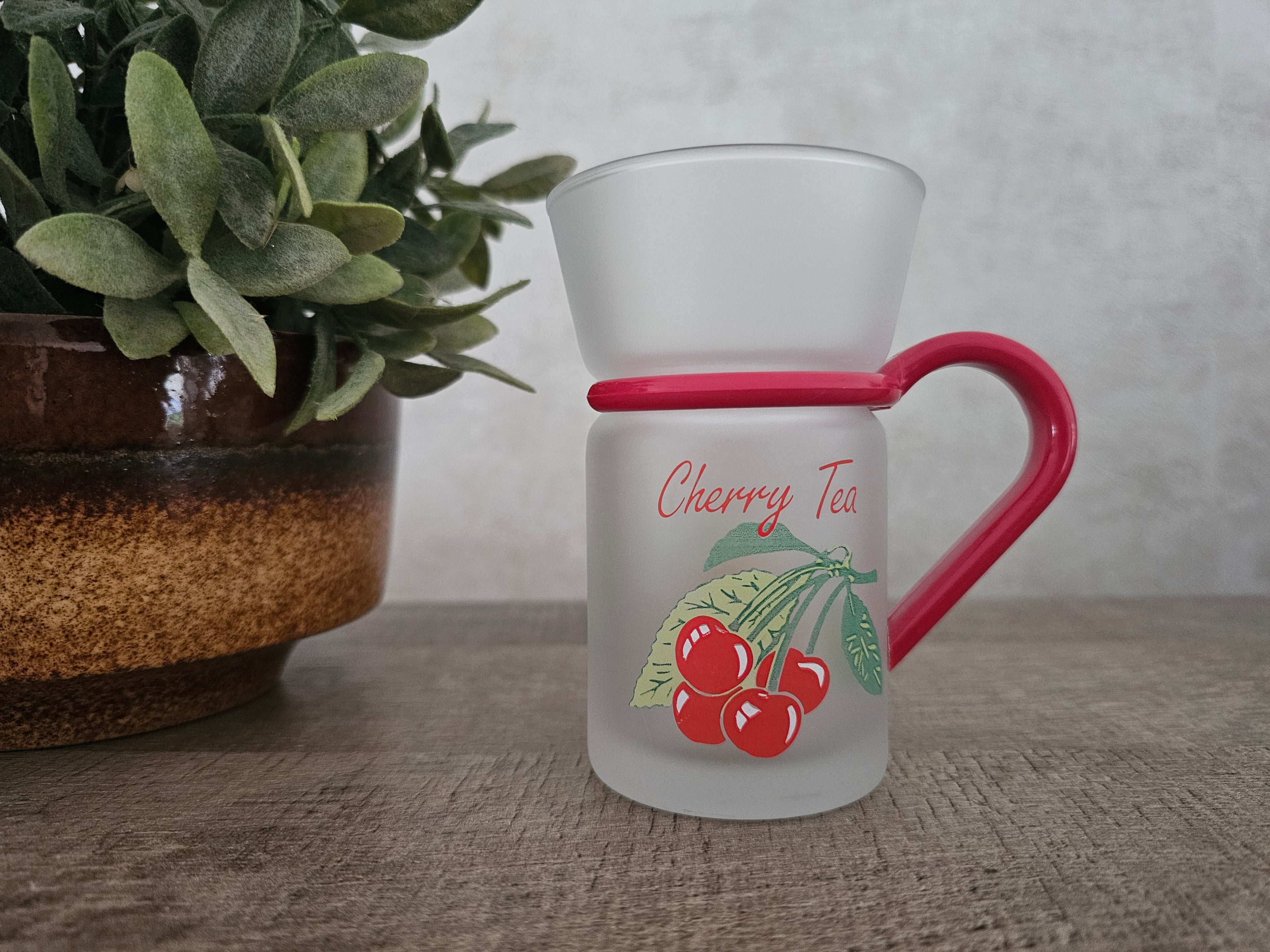 Jaren 80 / 90 vintage thee glas van mat glas met afbeelding van kersen aan 2 kanten.Tekst Cherry Tea. Glas heeft een rood handvat.
