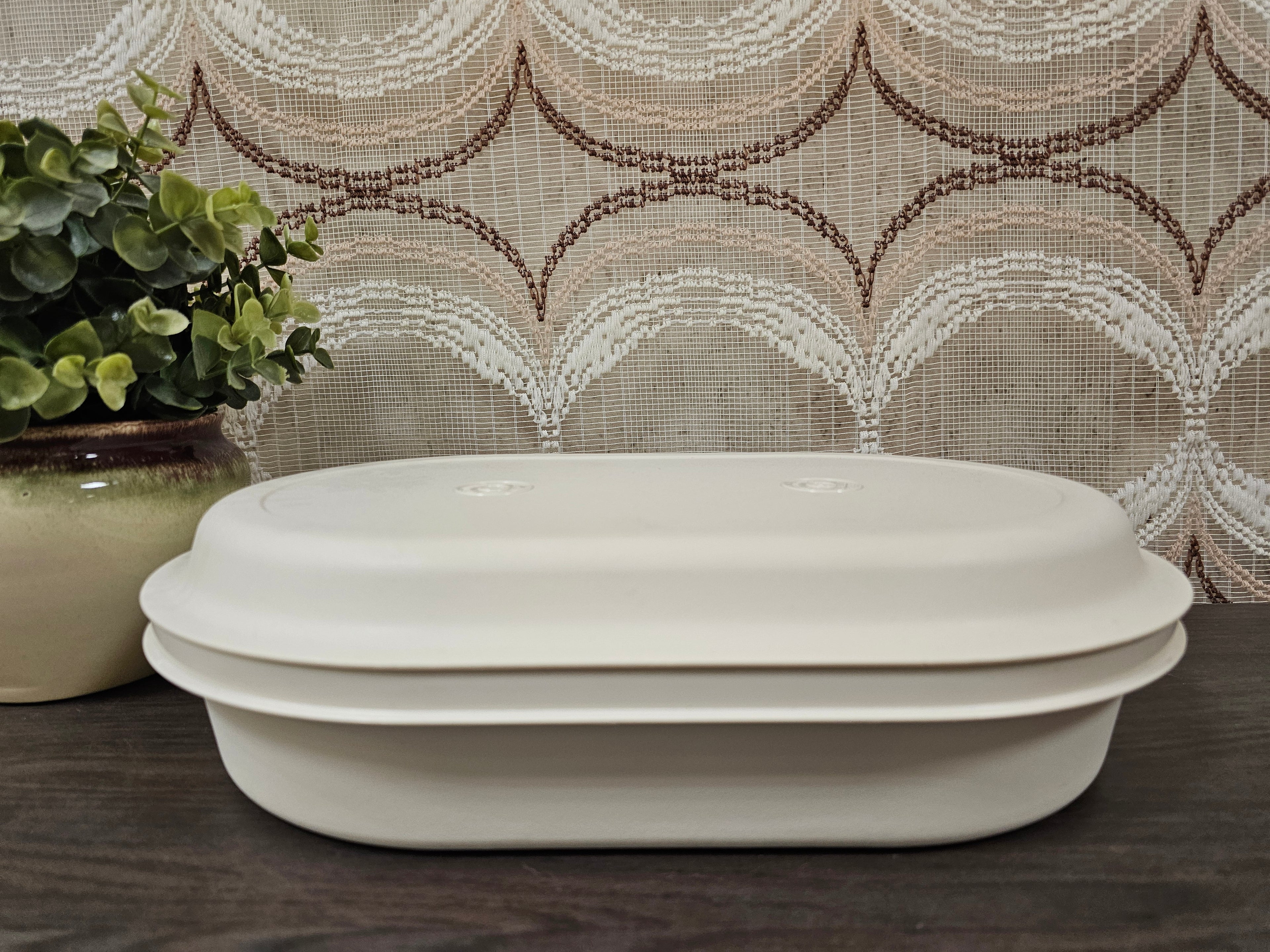 Crèmekleurige vintage serveerschaal van Tupperware met drie vakken en deksel, geschikt om warm of koel te serveren.