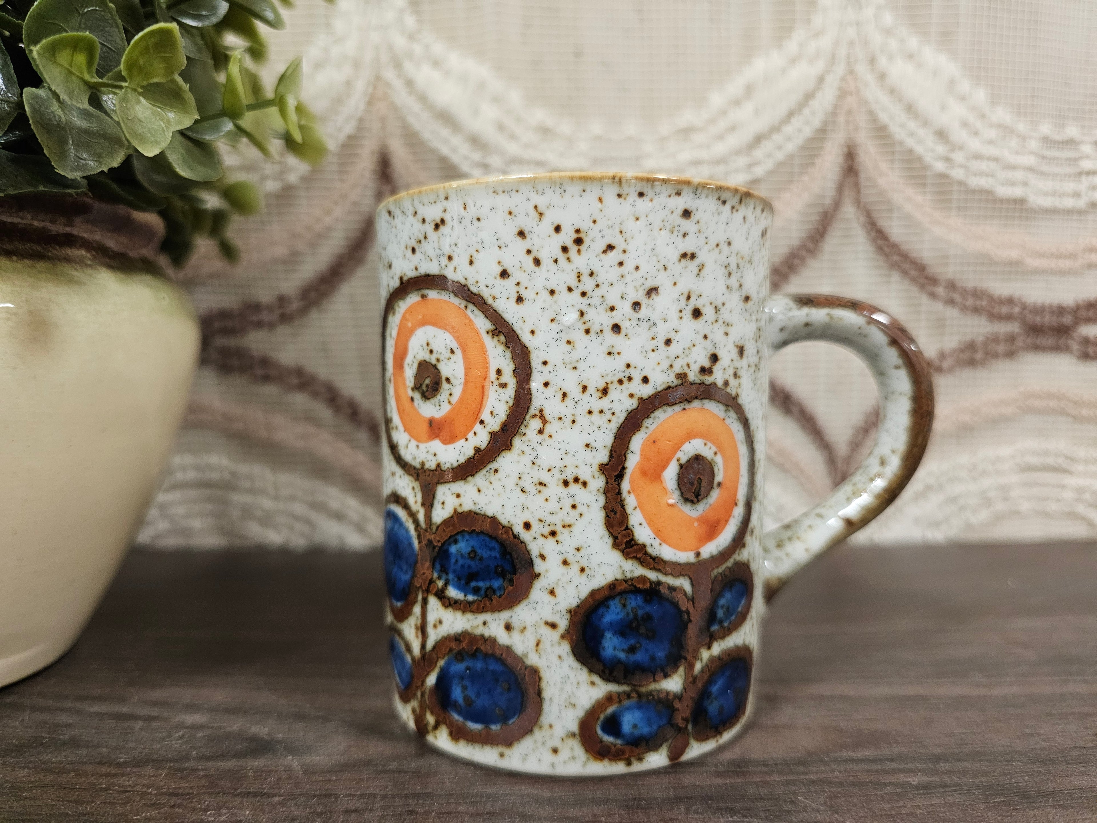 Vintage gespikkelde mok met blauw-oranje bloemenmotief, 9,5 cm hoog