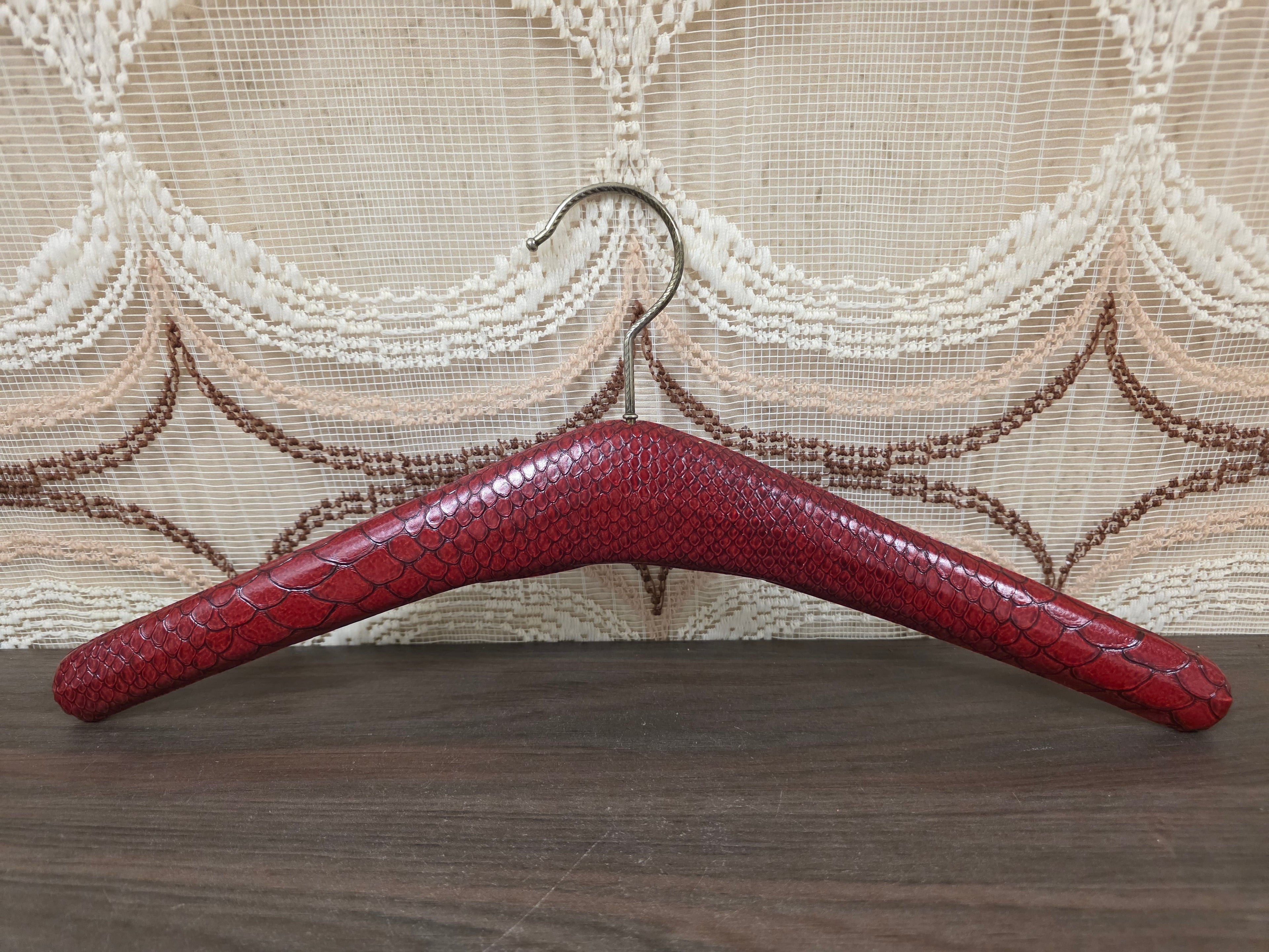 Vintage rode kledinghanger met slangenprint en metalen haak