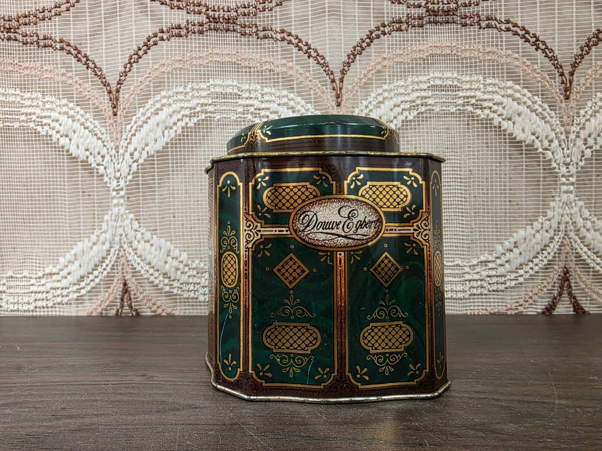 Detail van Douwe Egberts opschrift en goudkleurige versiering op het groene theeblik