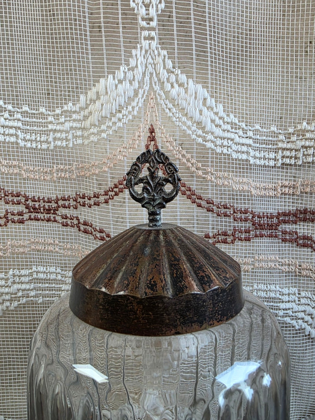 Detail van het metalen deksel met opengewerkte sierknop