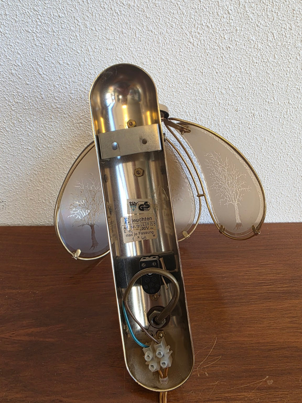 Achterzijde van de wandlamp met bevestigingsbeugel, snoer en etiket