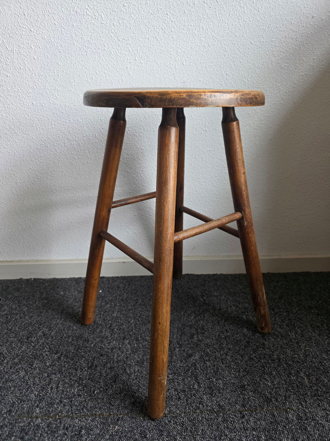 Houten kruk met schuine poten en verbindingsspijlen van opzij