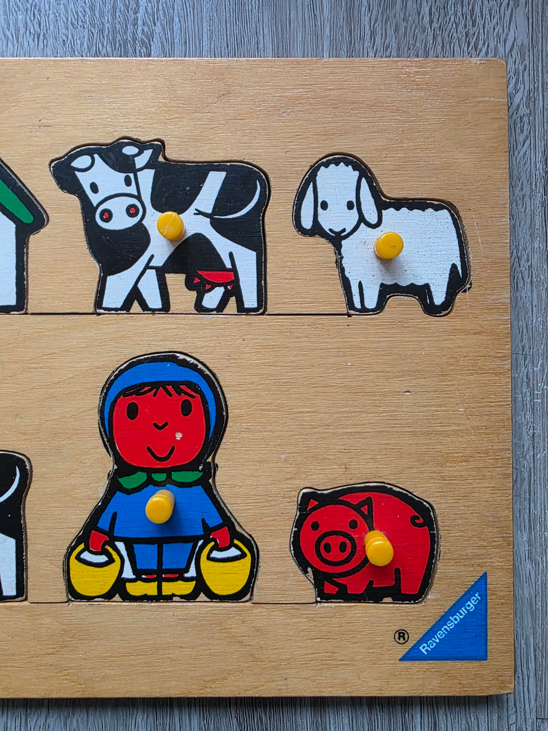 Detail van Dick Bruna puzzelstukken met meisje, varken, koe en schaap en Ravensburger-logo