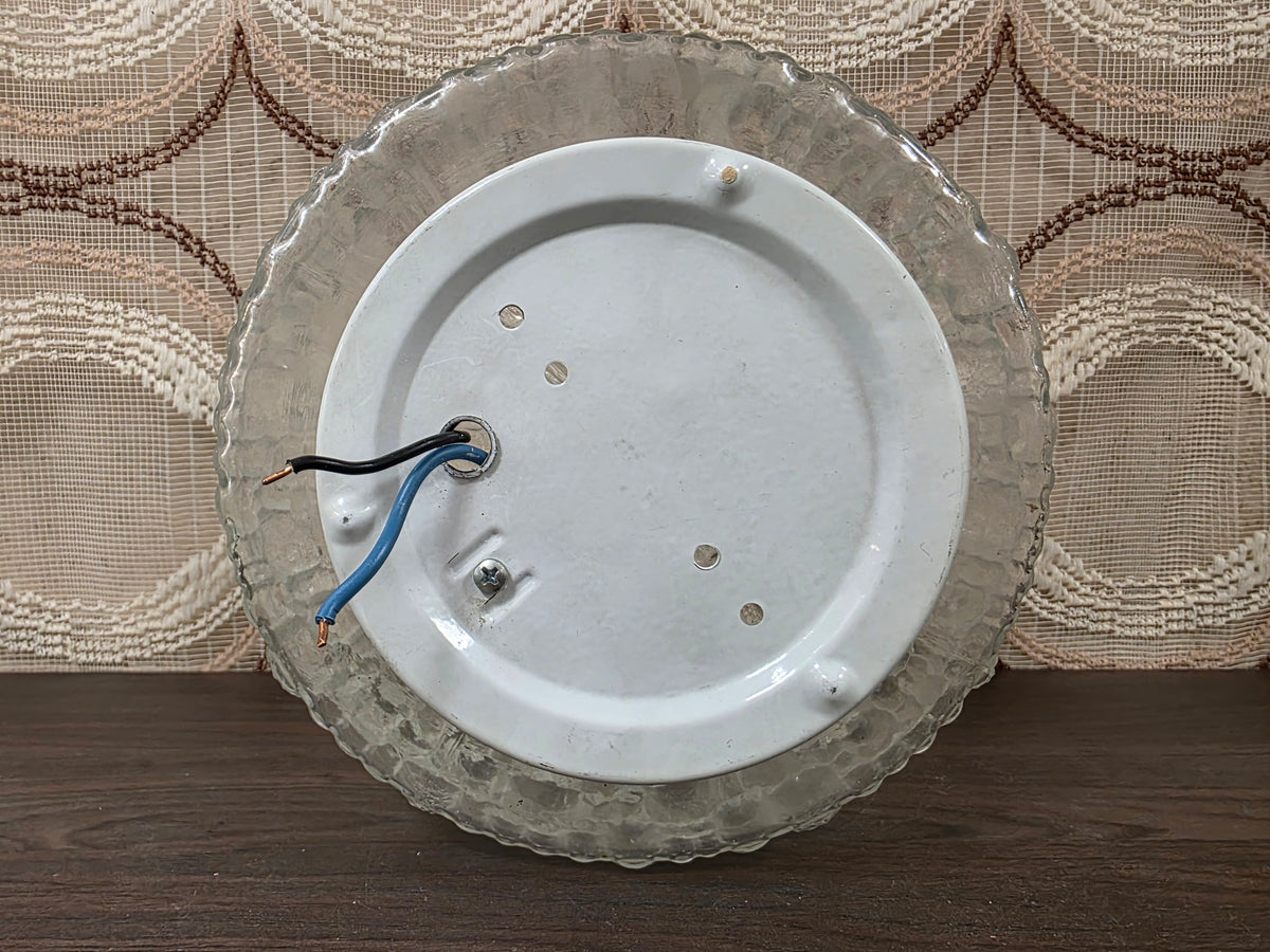 Achterzijde van de glazen plafondlamp met witte montageplaat en twee aansluitdraden