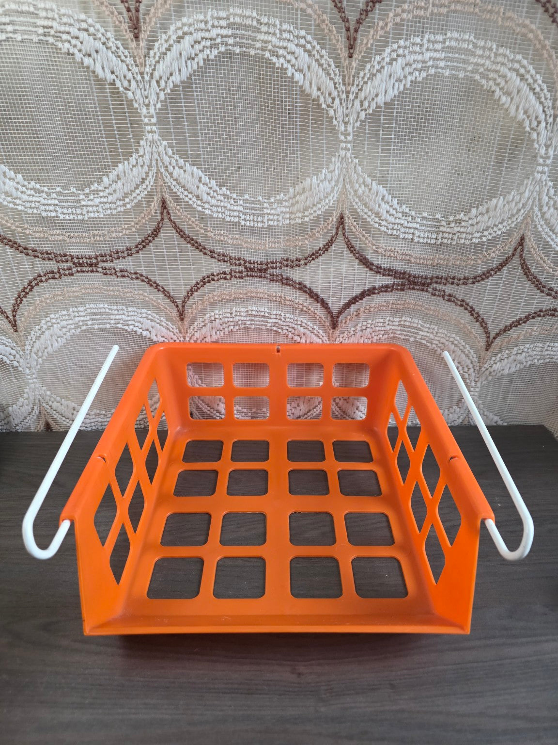 Oranje vintage hangmandje met witte beugels, gezien vanaf de voorkant