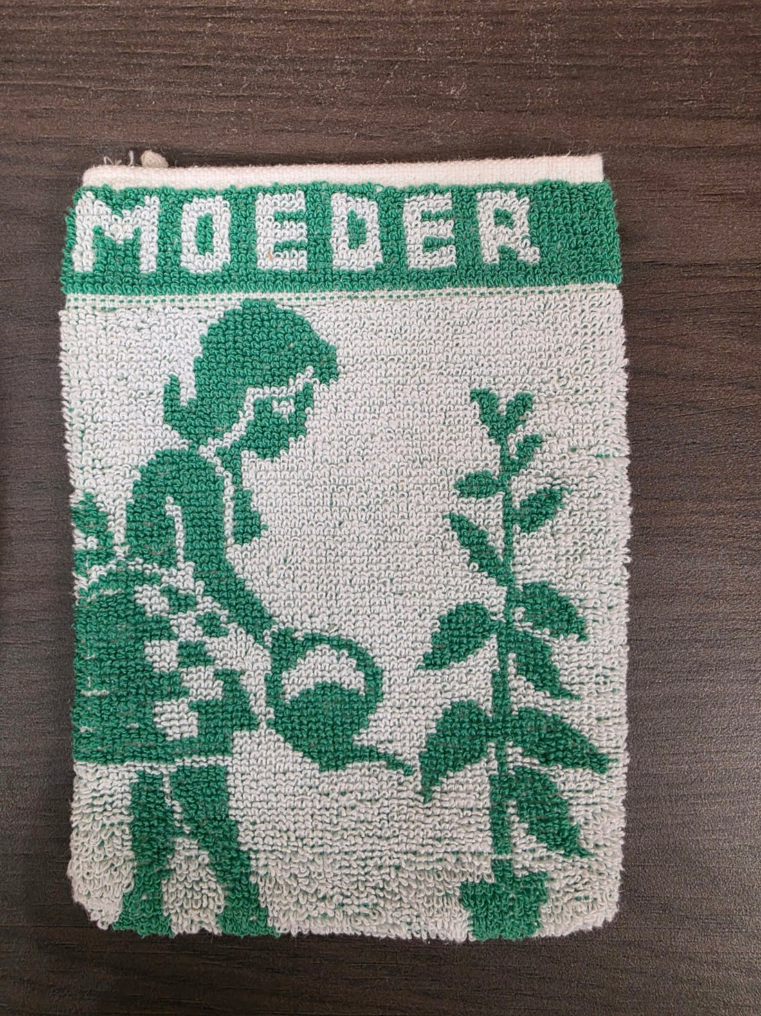Detail van groen-wit washandje met opschrift MOEDER en afbeelding van vrouw met bloemen