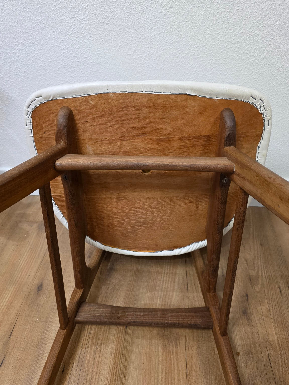Onderzijde van een stoel met houten zitting en bevestiging van de bekleding