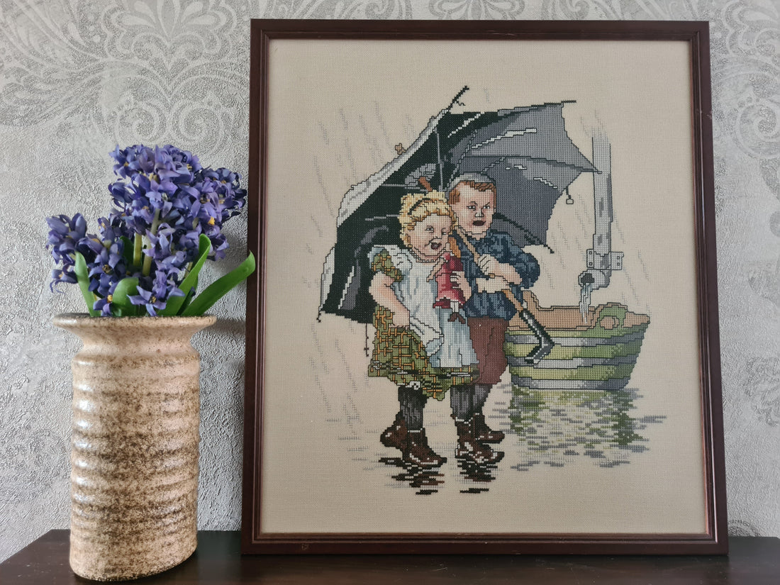 Ingelijst borduurwerk Ot & Sien onder moeders paraplu