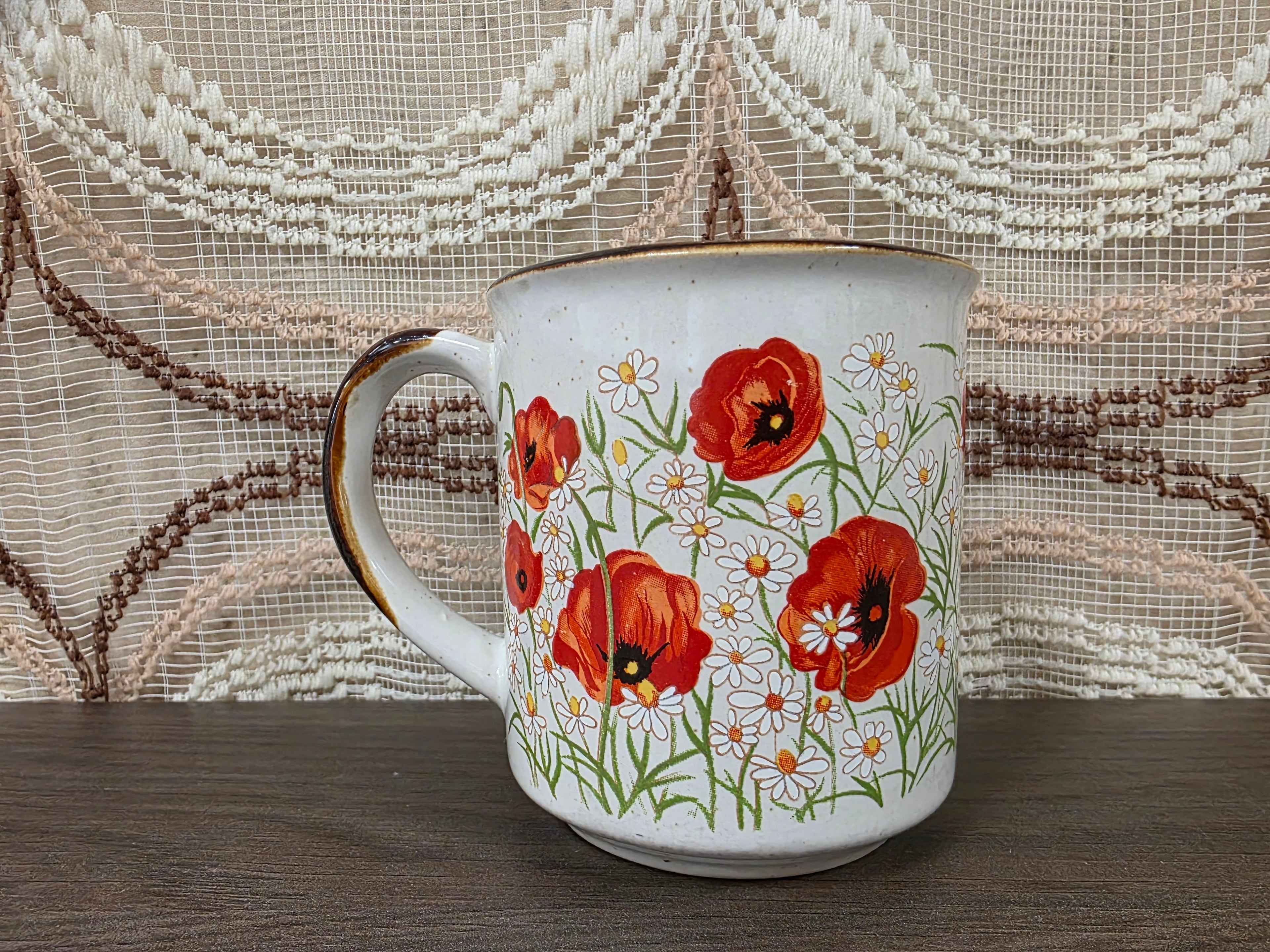 Vintage koffiebeker met klaprozen en margrieten
