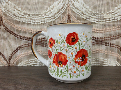 Vintage koffiebeker met klaprozen en margrieten