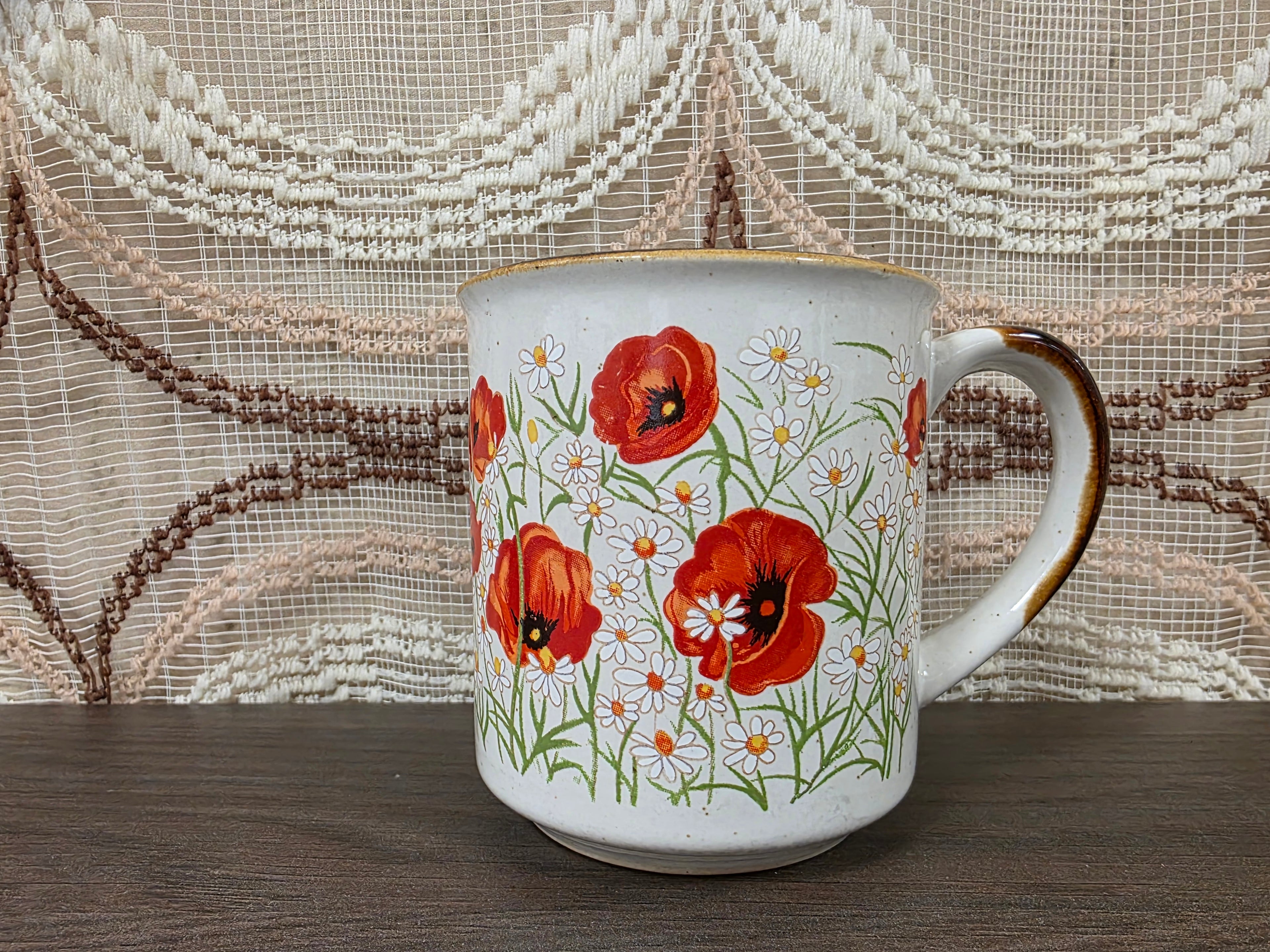 Vintage koffiebeker met klaprozen en margrieten