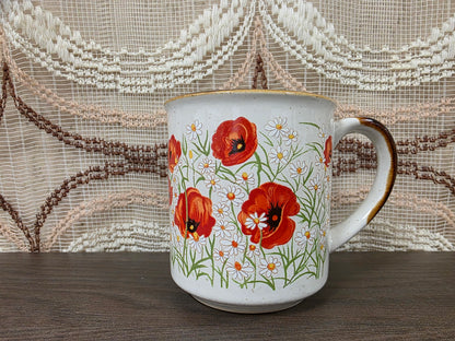 Vintage koffiebeker met klaprozen en margrieten