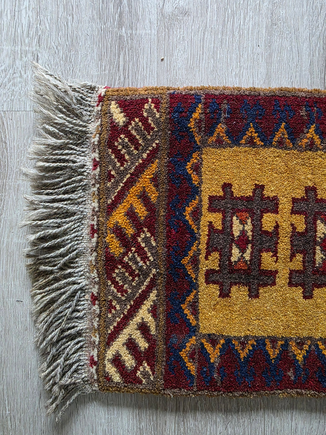 Klein kleedje met geometrisch patroon – okergeel en bordeaux