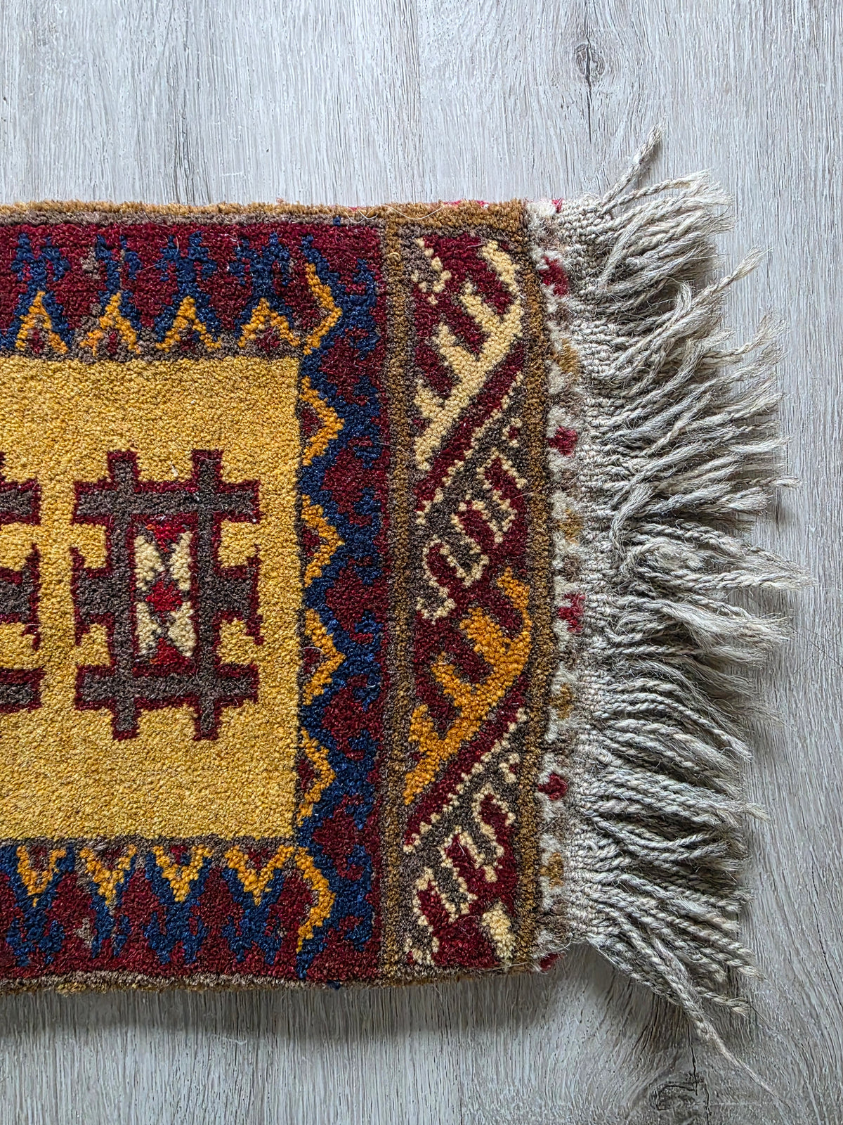 Klein kleedje met geometrisch patroon – okergeel en bordeaux