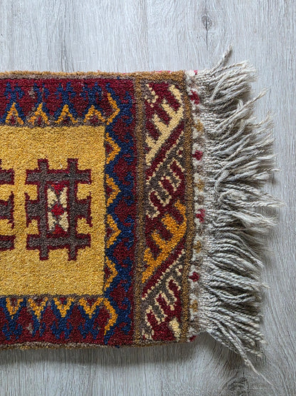 Klein kleedje met geometrisch patroon – okergeel en bordeaux