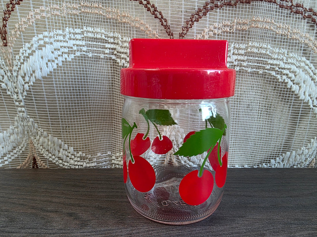 Vintage glazen voorraadpot met kersen en rode dop