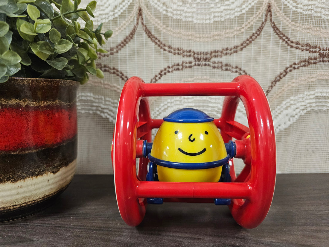 Vintage Ambi Toys Humpty Dumpty roller – rood-geel babyspeelgoed met blauw petje, lachend gezicht en ronde vorm