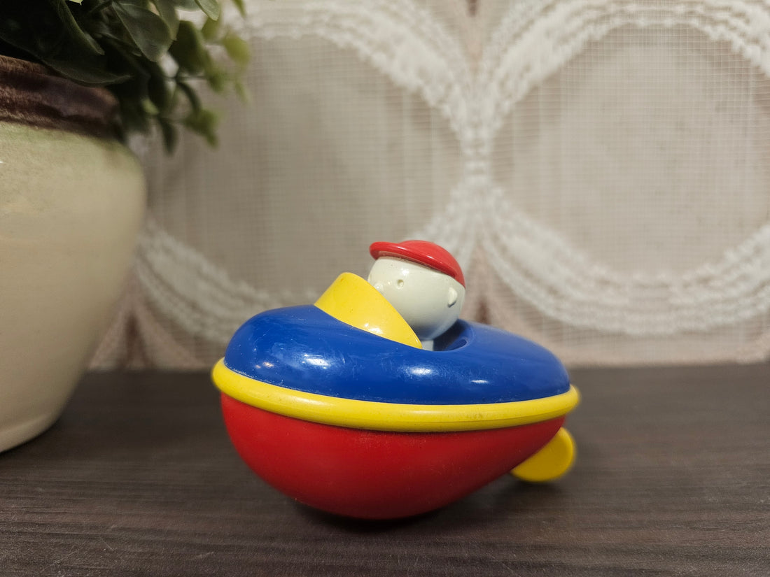 Kleine kunststof speelgoedboot van Ambi Toys uit de jaren ’90 in heldere kleuren.