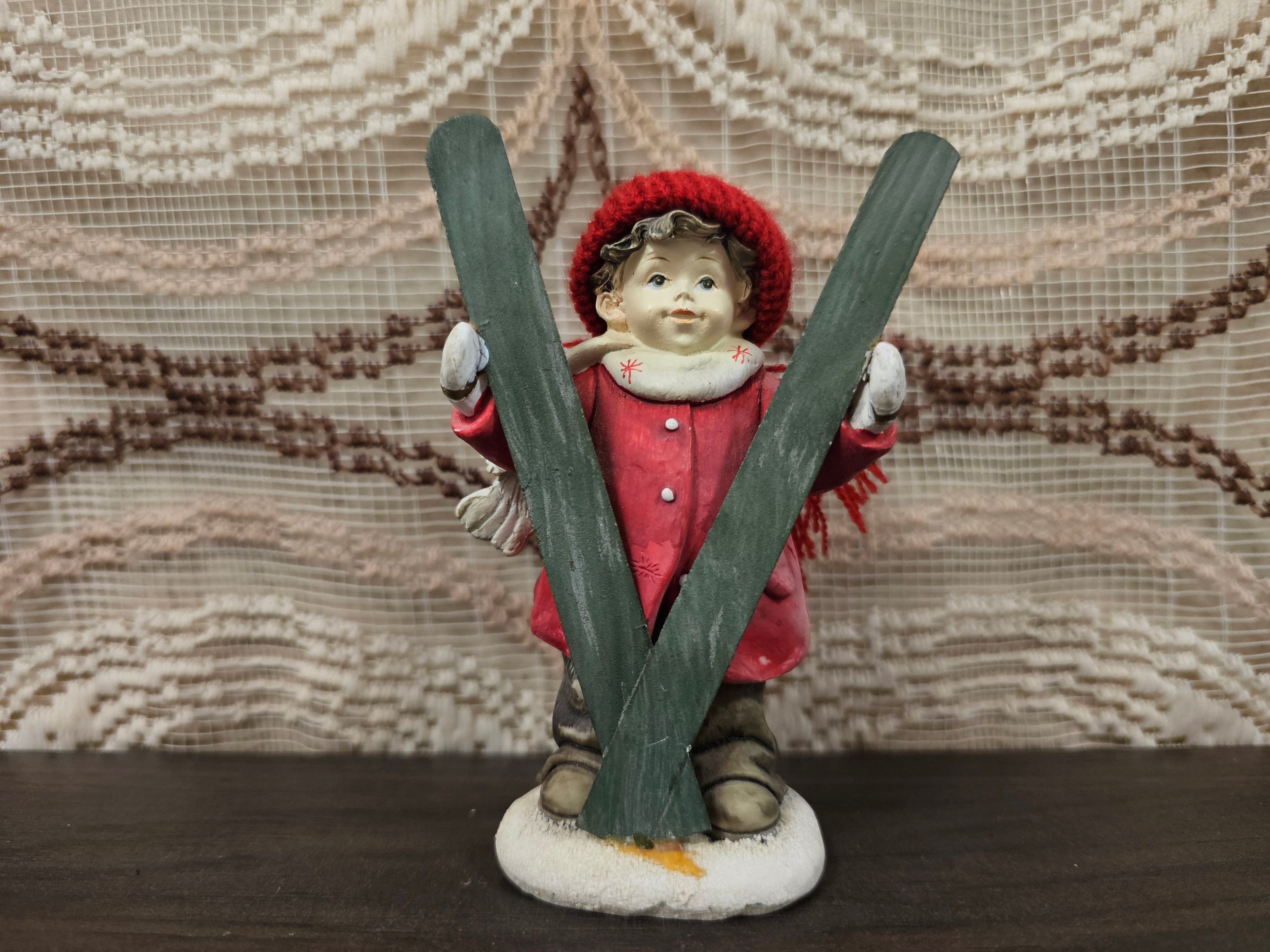 Beeldje jongen met rode jas en ski’s, ca. 11 cm hoog