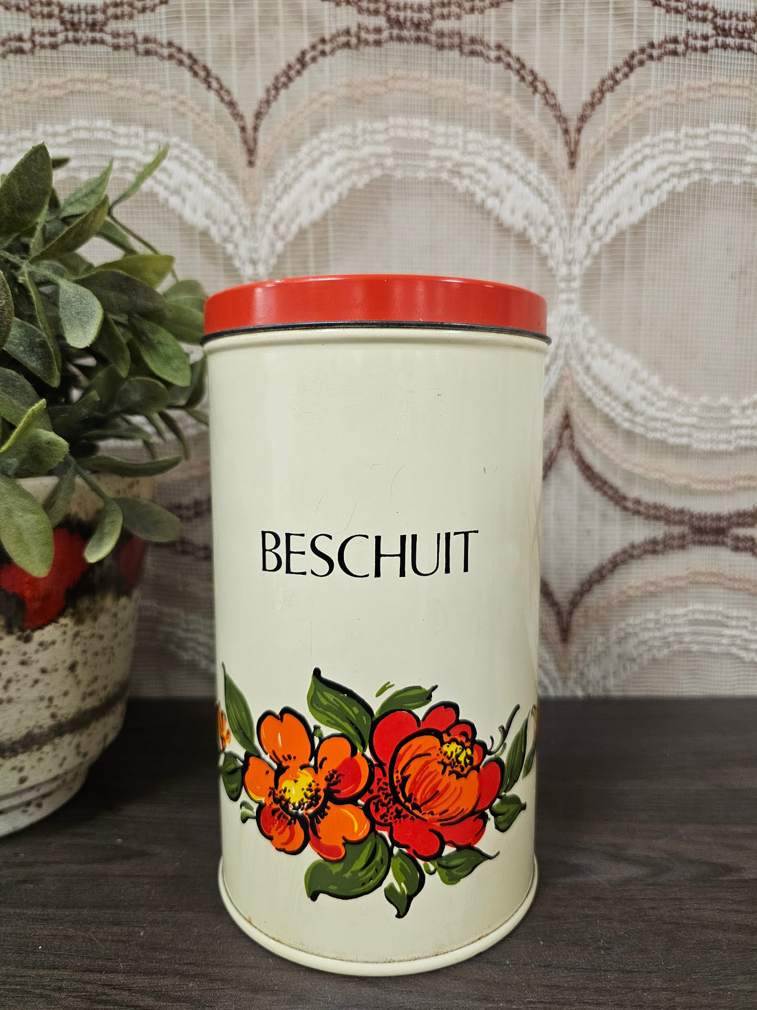 Vintage beschuitblik met oranje en rode bloemen en rode deksel – jaren ’70 stijl