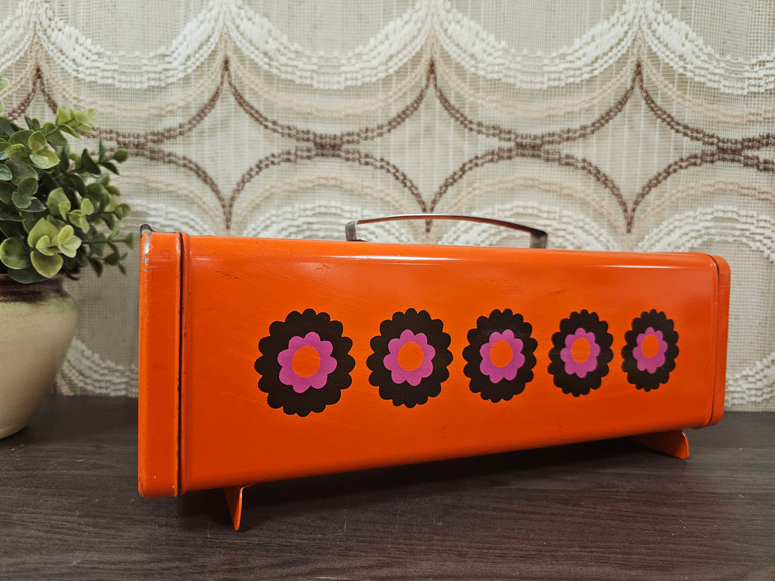 
Brabantia Patrice vintage oranje ontbijtkoekblik jaren 70 met bloemendessin, 32x12x10,5 cm, met gebruikerssporen. 