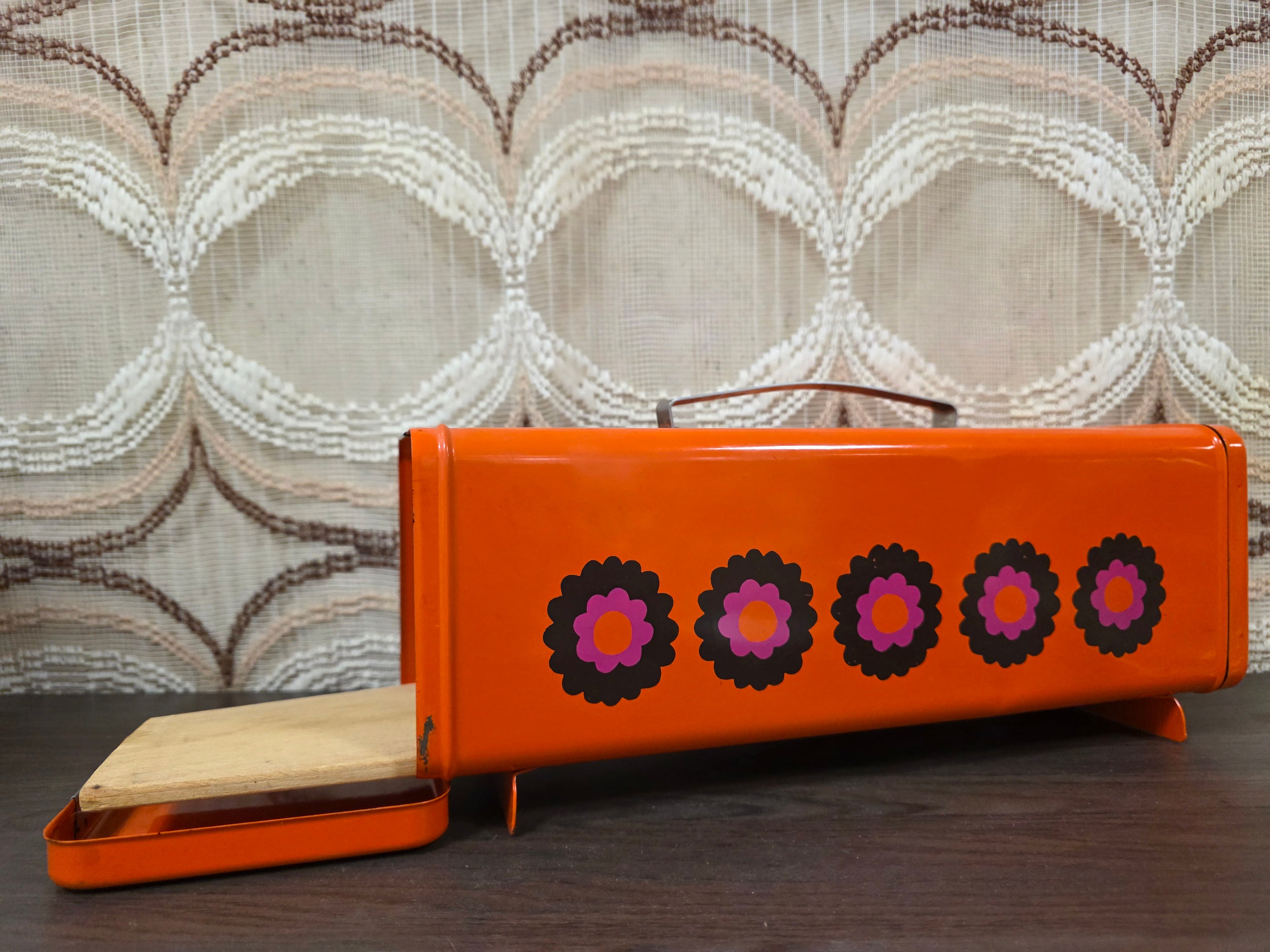 Vintage Brabantia ontbijtkoekblik Patrice in oranje met kleurrijk bloemenpatroon uit de jaren 70, inclusief origineel plankje.