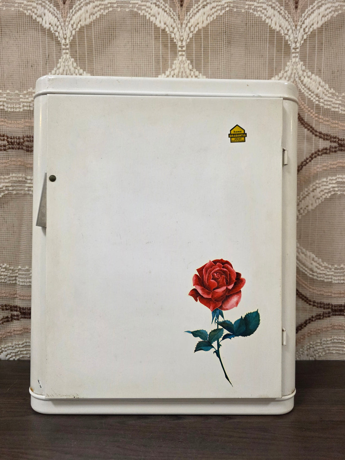 Vintage wit metalen Brabantia medicijnkastje met rode roos op de deur en plankje binnenin