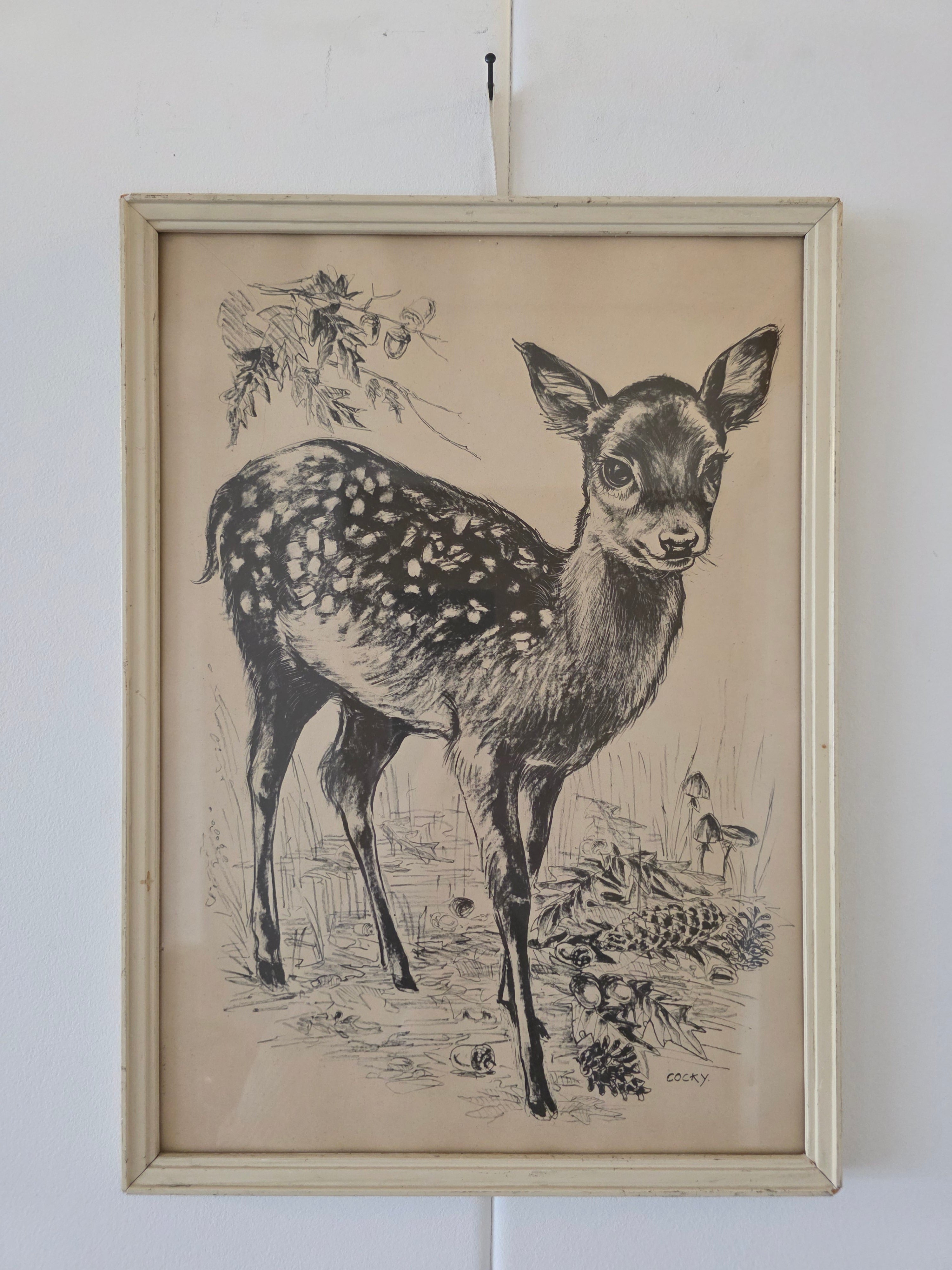 Grijze prent van jong hertje met bosgrond, gesigneerd Cocky, in lichte houten lijst