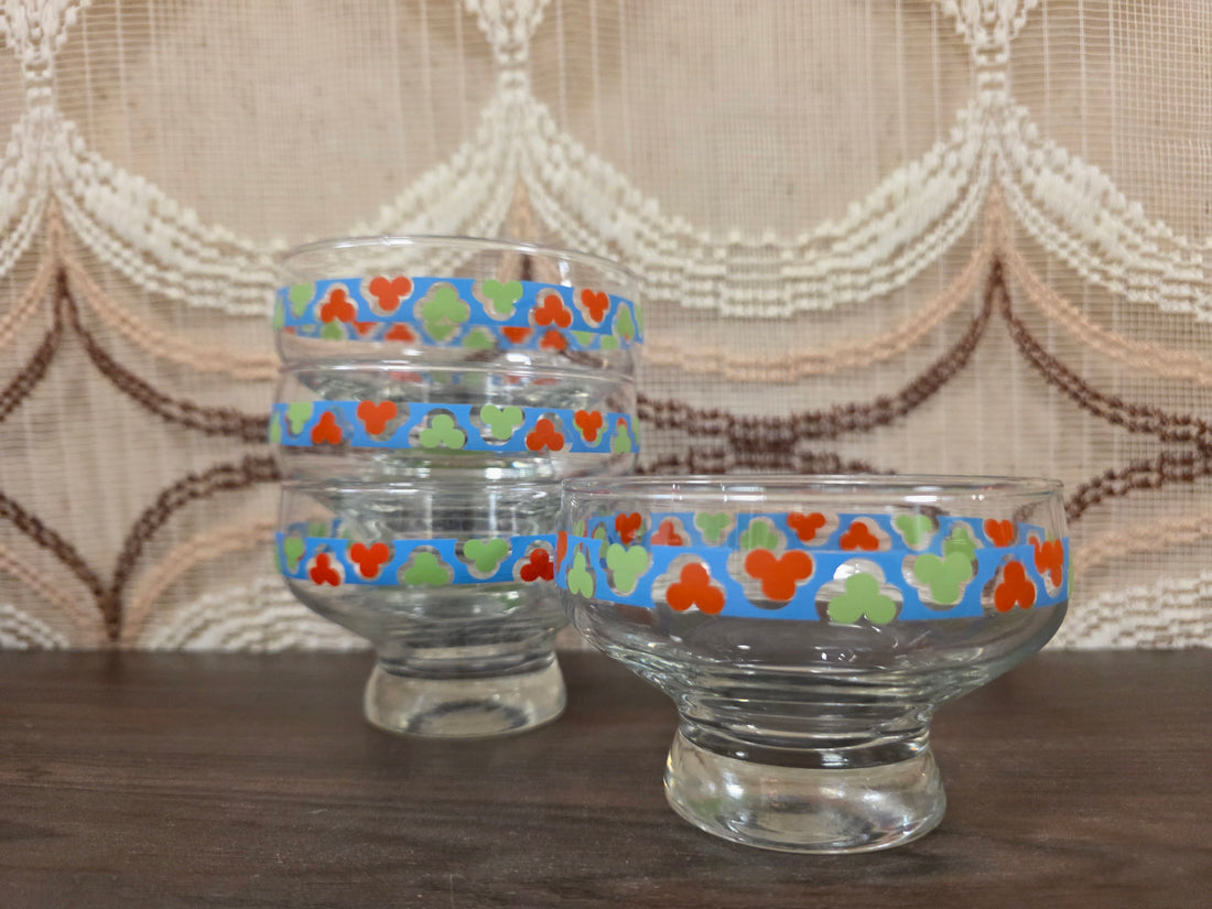 vintage glazen dessertschaaltjes op voet met blauw, rood, groen en wit decor.