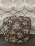Vintage Douwe Egberts theebeurs met bloemenpatroon en metalen knipsluiting met DE-logo.