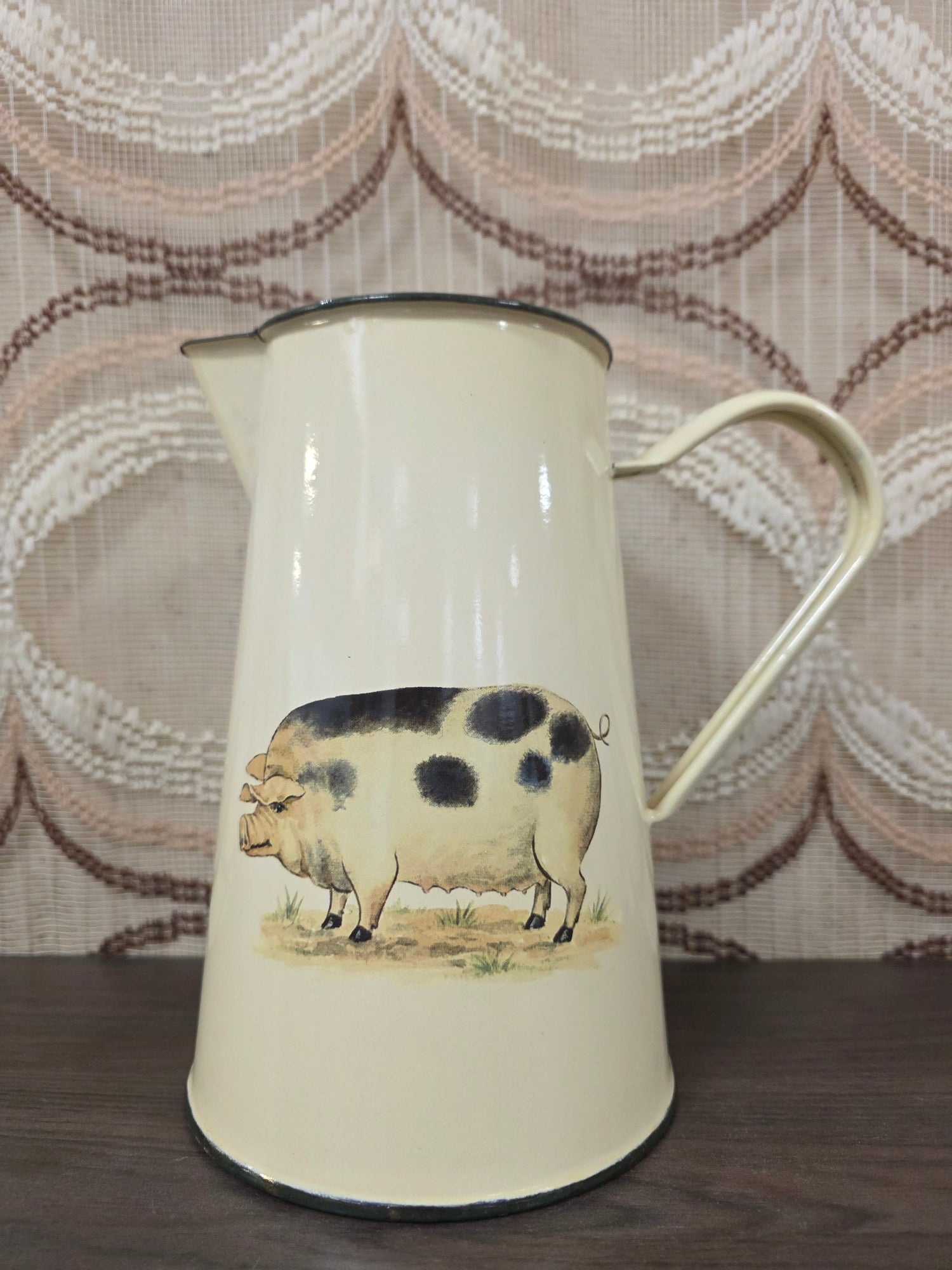 Vintage crèmekleurige emaille schenkkan met afbeelding van een bont varken