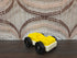 Vintage Fisher-Price autootje in geel wit met zwarte wielen.