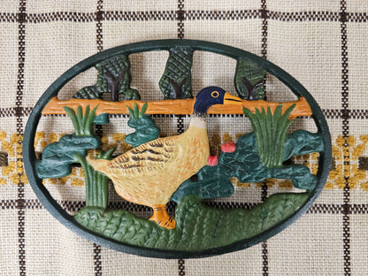 Gietijzeren onderzetter met afbeelding van eend in gras en riet – handgeschilderd – ovaal, 20,5 x 14,5 cm