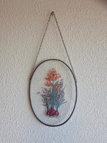 Vintage glas-in-lood raamhanger met bloemen in ovaal metalen frame en ophangketting.