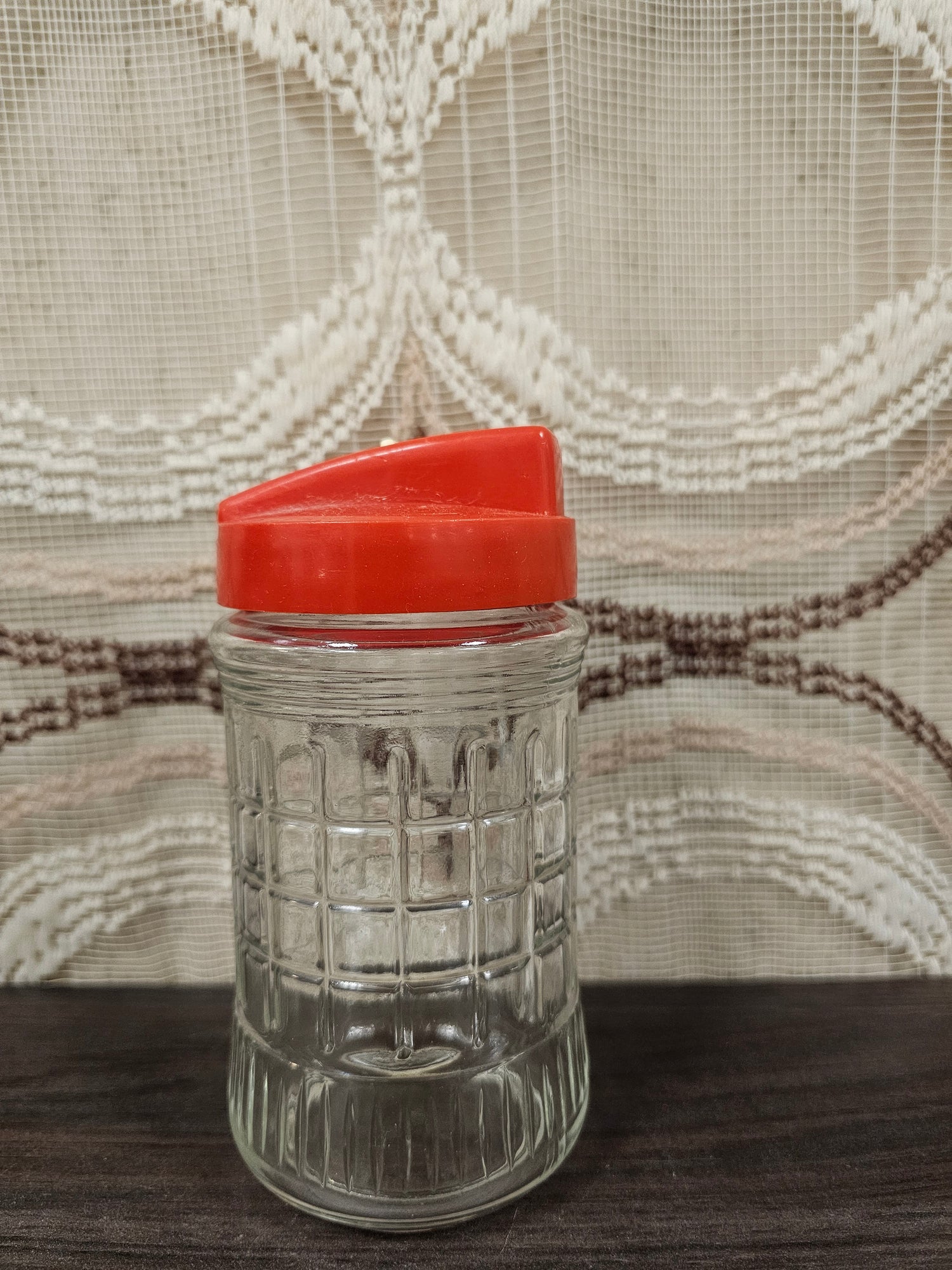 Oude glazen strooier met rood plastic deksel en schuifdop, geschikt voor hagelslag