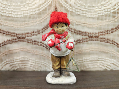 Kerstbeeldje jongen met triangel en rode muts – 11 cm hoog
