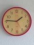 Vintage Kienzle quartz wandklok met rode rand en crèmekleurige wijzerplaat, diameter 22 cm.
