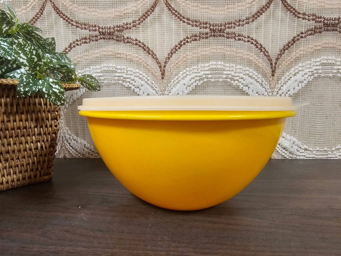 Licht oranje vintage Tupperware kom met deksel, 17,5 cm diameter en 9 cm hoog, geschikt voor bewaren en serveren.
