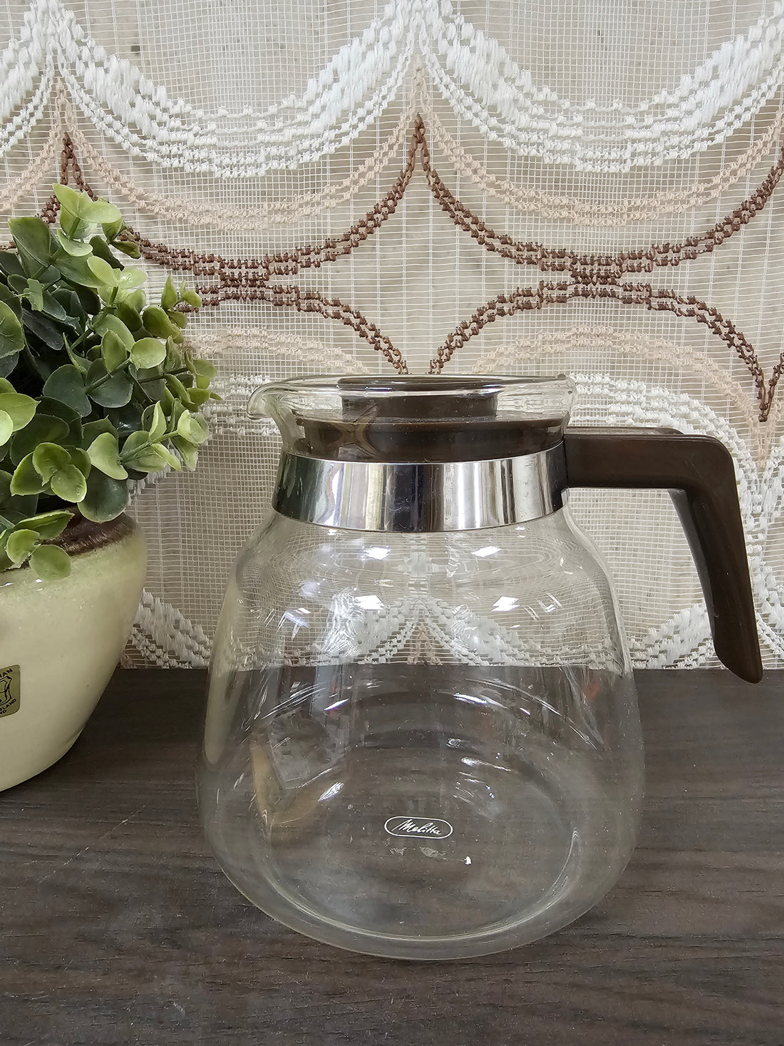 Vintage glazen koffiekan van Melitta met bruin kunststof deksel en handvat, geschikt voor filterkoffie.