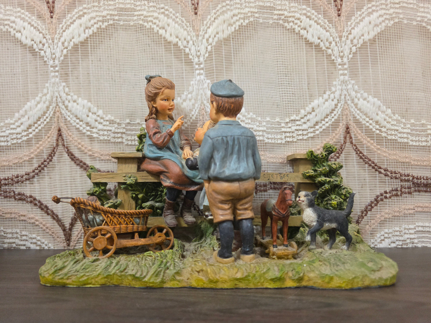 Ot en Sien beeld bij houten hek met kinderwagen pop poes en speelgoedpaardje