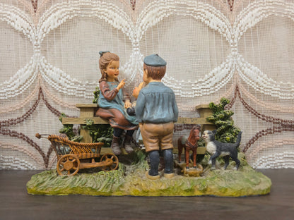 Ot en Sien beeld bij houten hek met kinderwagen pop poes en speelgoedpaardje