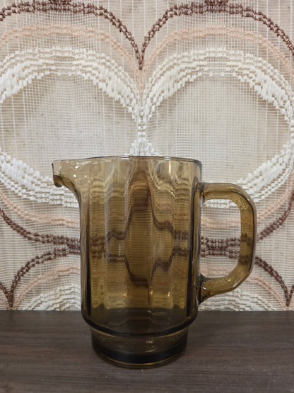 Vintage rookglas karaf van dik glas met verticale lijnen en een stevige handgreep.