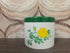 Vintage SENO voorraadpot met gele roos, groene deksel en witte kunststof pot.